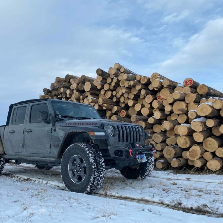 jeep in front of log pile knotty pine milling 768x768